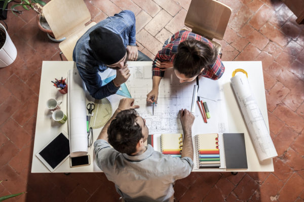 Teamwork. Three young architects working on a project