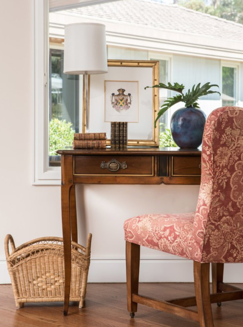 warm wooden desk with red vintage chair in California Cool sophisticated home