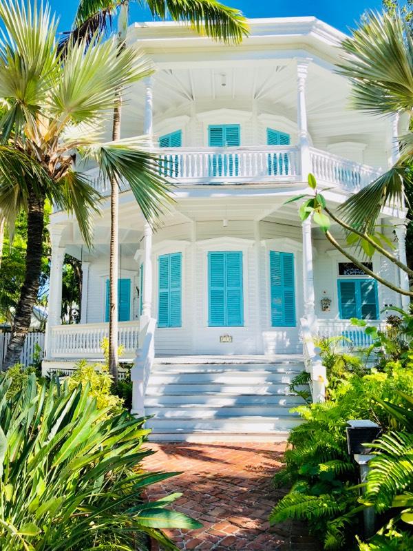 Old town Key West white home with porch and teal shutters