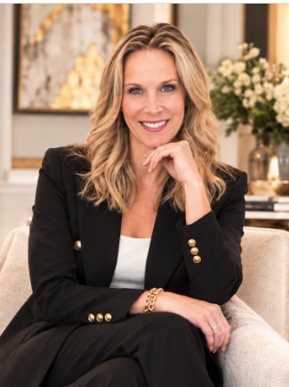Lori Dennis, interior design expert witness, seated in a cream chair wearing a black suit.